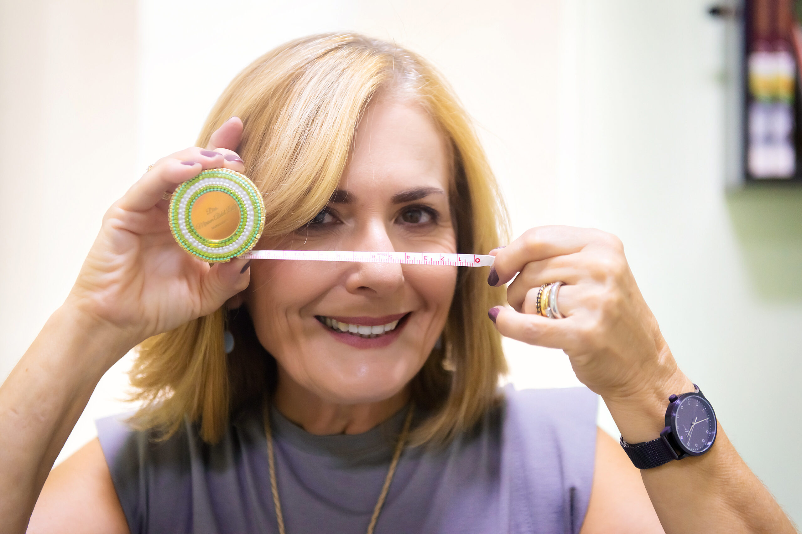 Nutricionista Miriam Abdel Latif sorrindo enquanto realiza medição antropométrica com fita métrica em consultório em Americana-SP.